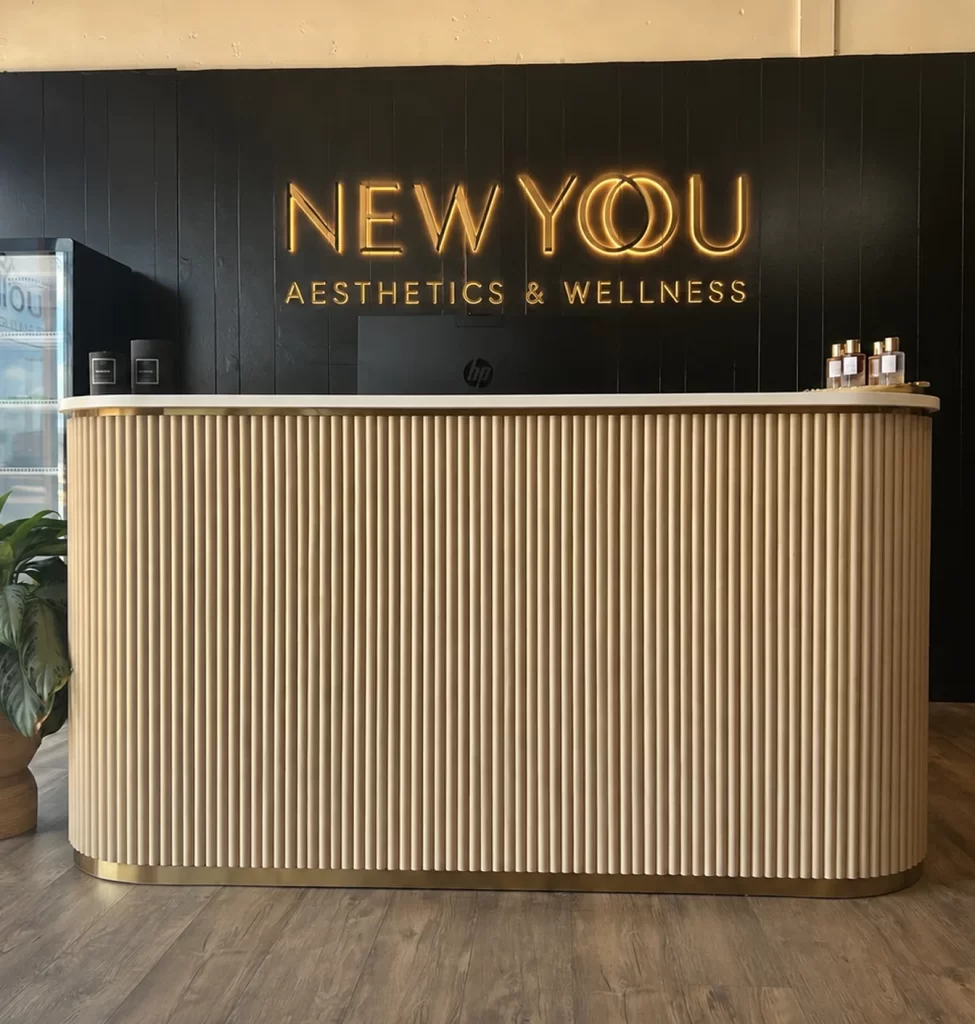 Reception desk with New You Aesthetics & Wellness sign in Marshall, TX