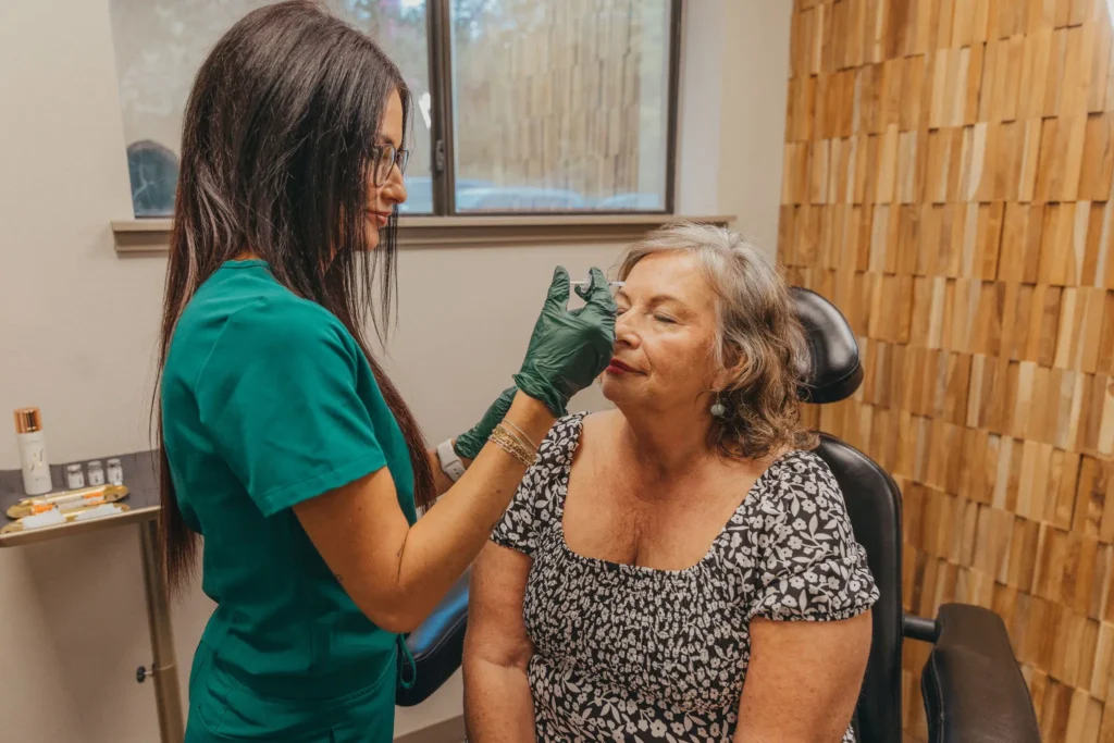 Provider assessing a client's face before a biostimulator treatment