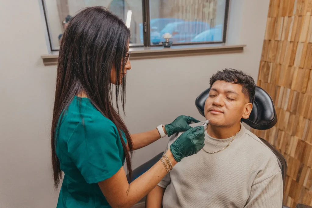 Provider marking a male client's face before dermal filler treatment