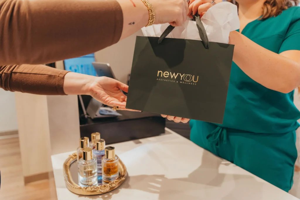 Member receiving a New You Aesthetics & Wellness gift bag