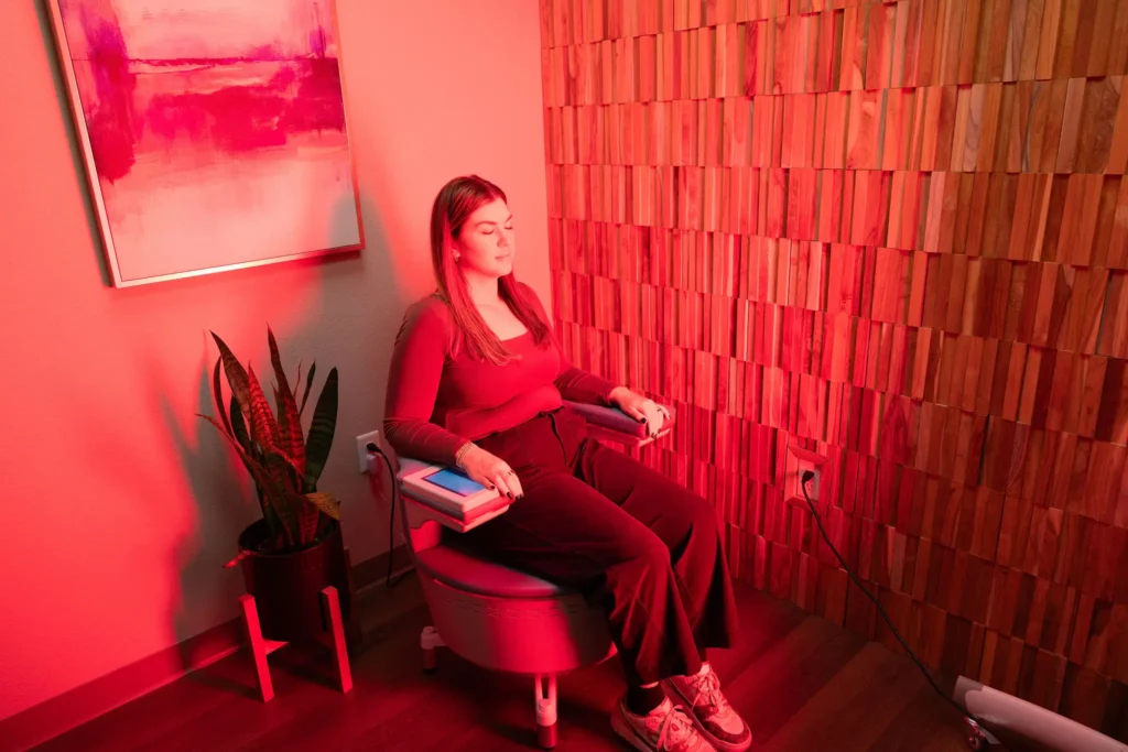 Client relaxing in a red light therapy room